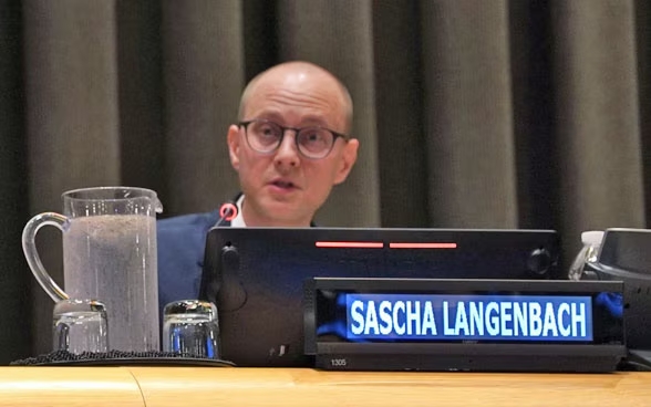 ETH representative Sascha Langenbach speaking at a UN Security Council meeting, seated behind a nameplate.