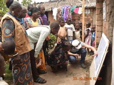 People in Betou (Republic of Congo) standing in front of a map and discussing risk mapping