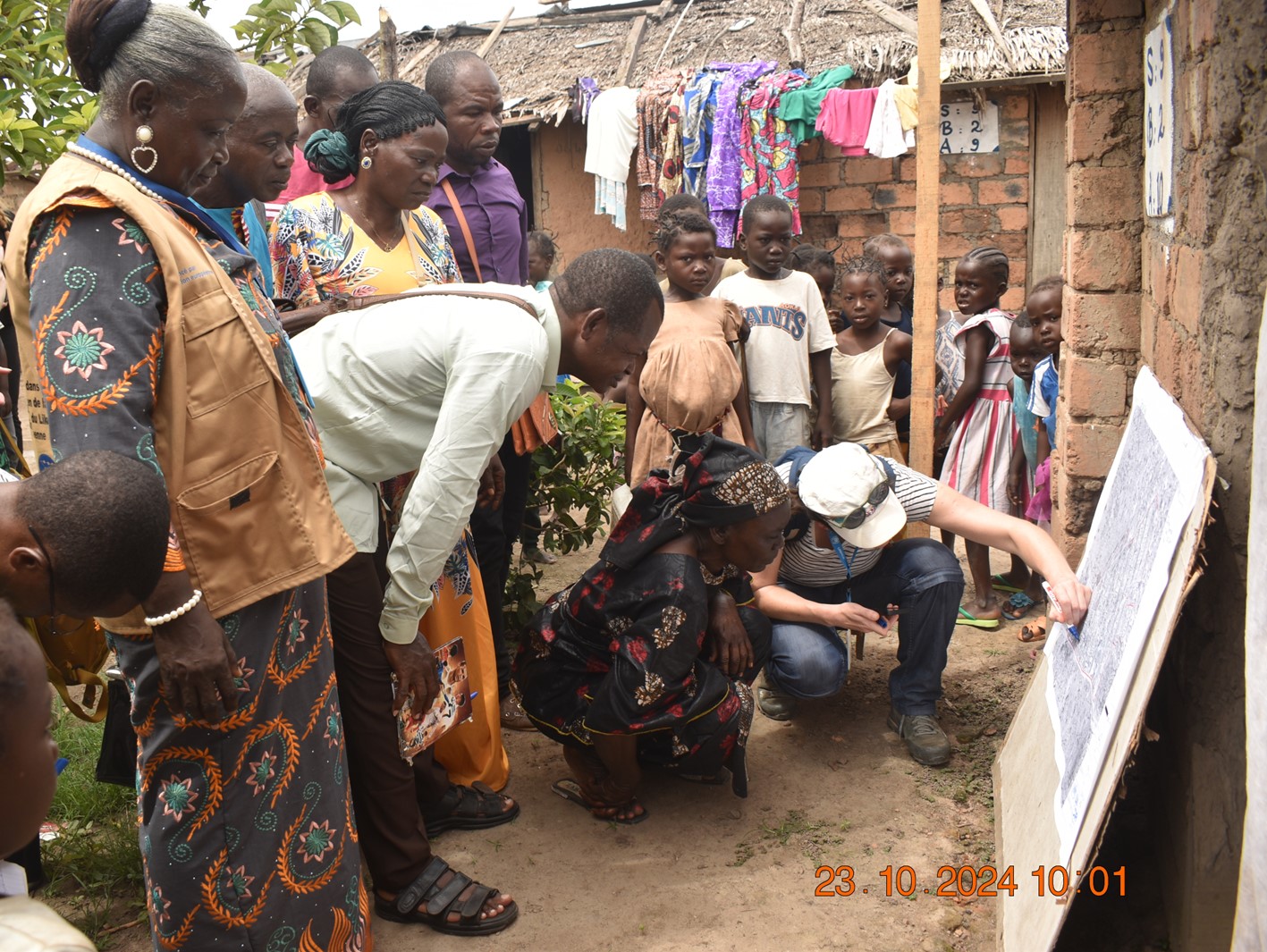 People in Betou (Republic of Congo) standing in front of a map and discussing risk mapping